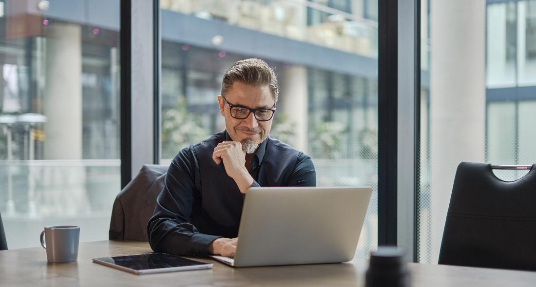 A cybersecurity professional working at their desk, learning about cybersecurity frameworks.