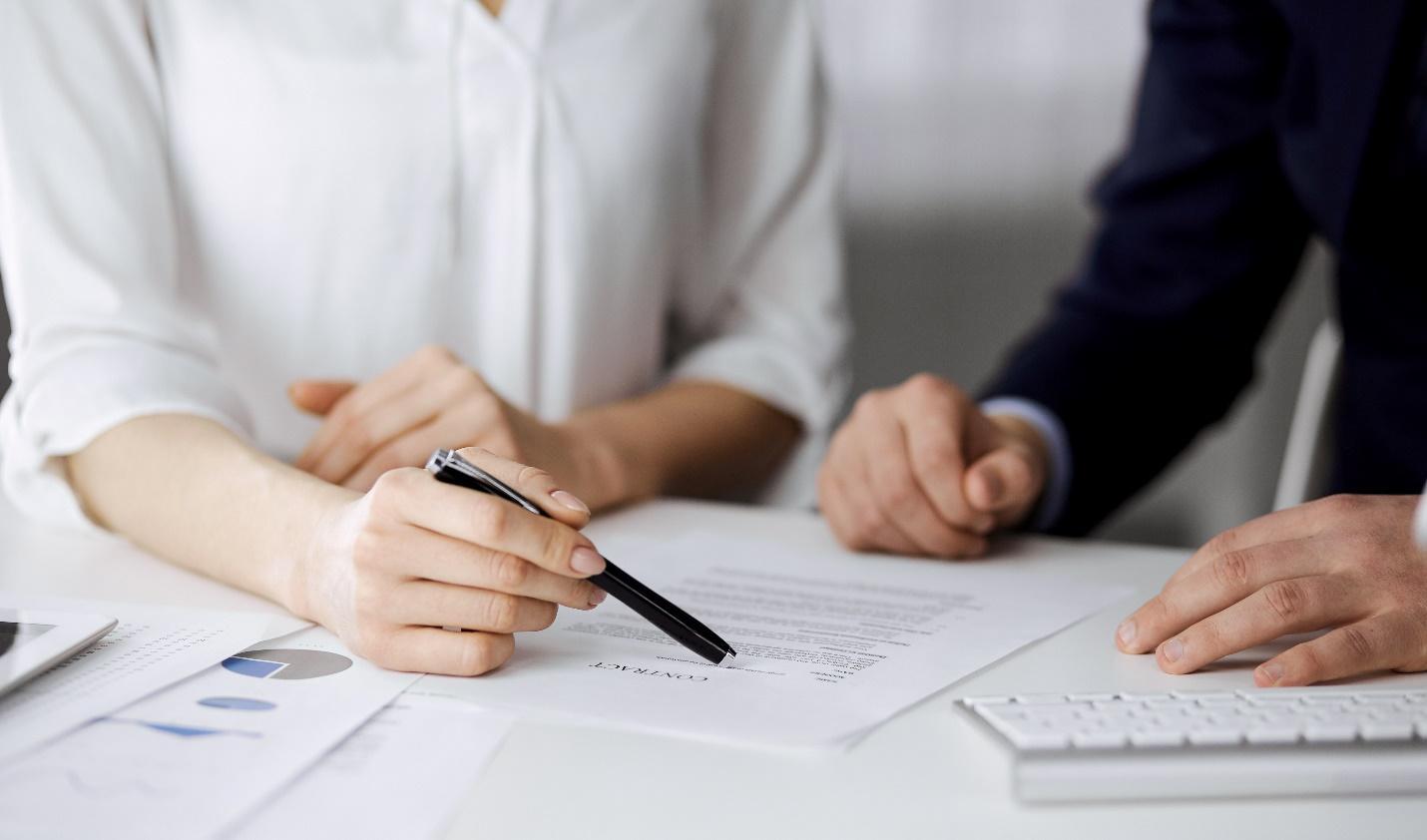 Two employees reviewing a contract at a desk.