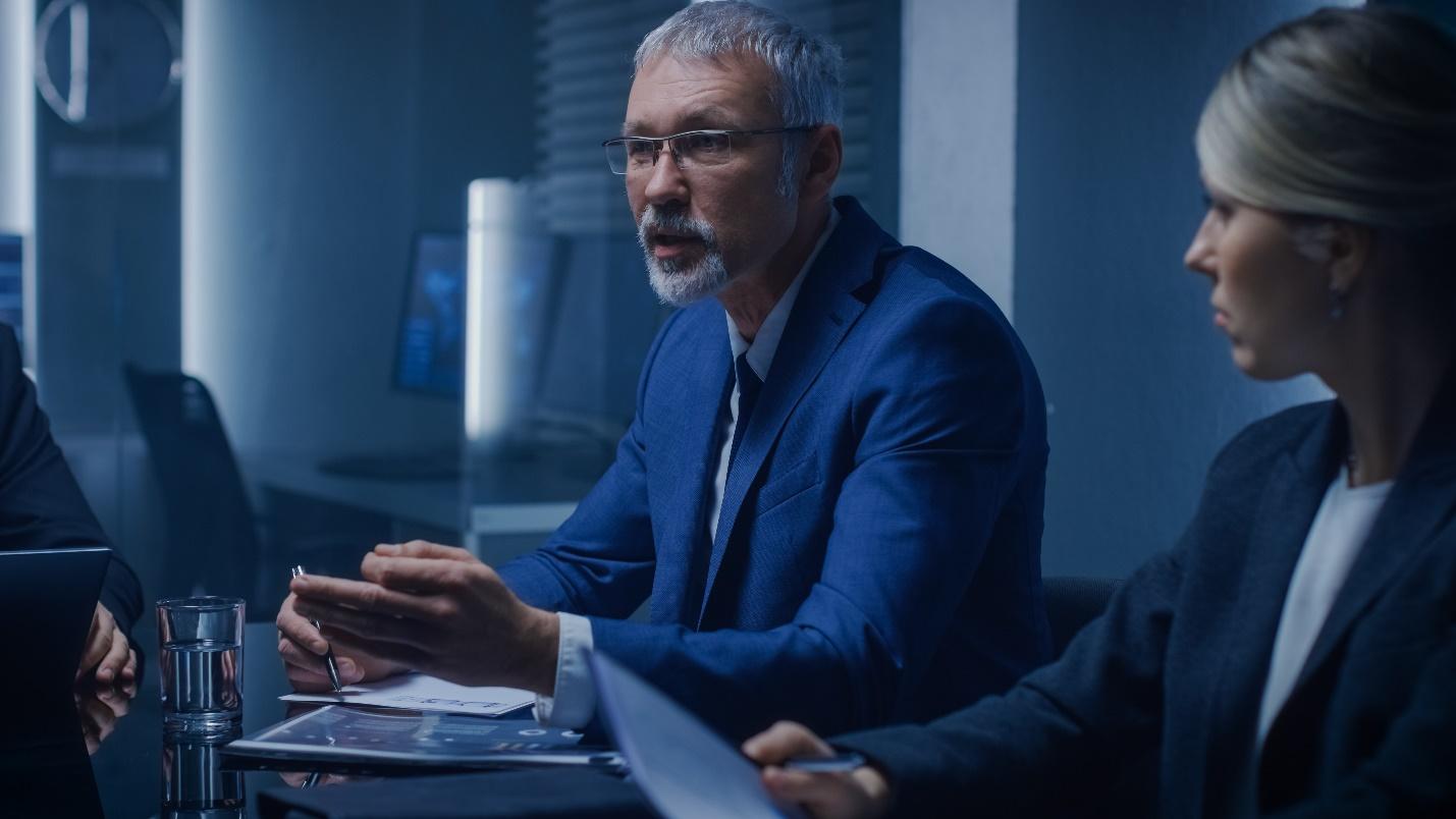 Two IT professionals confer in a situation room.