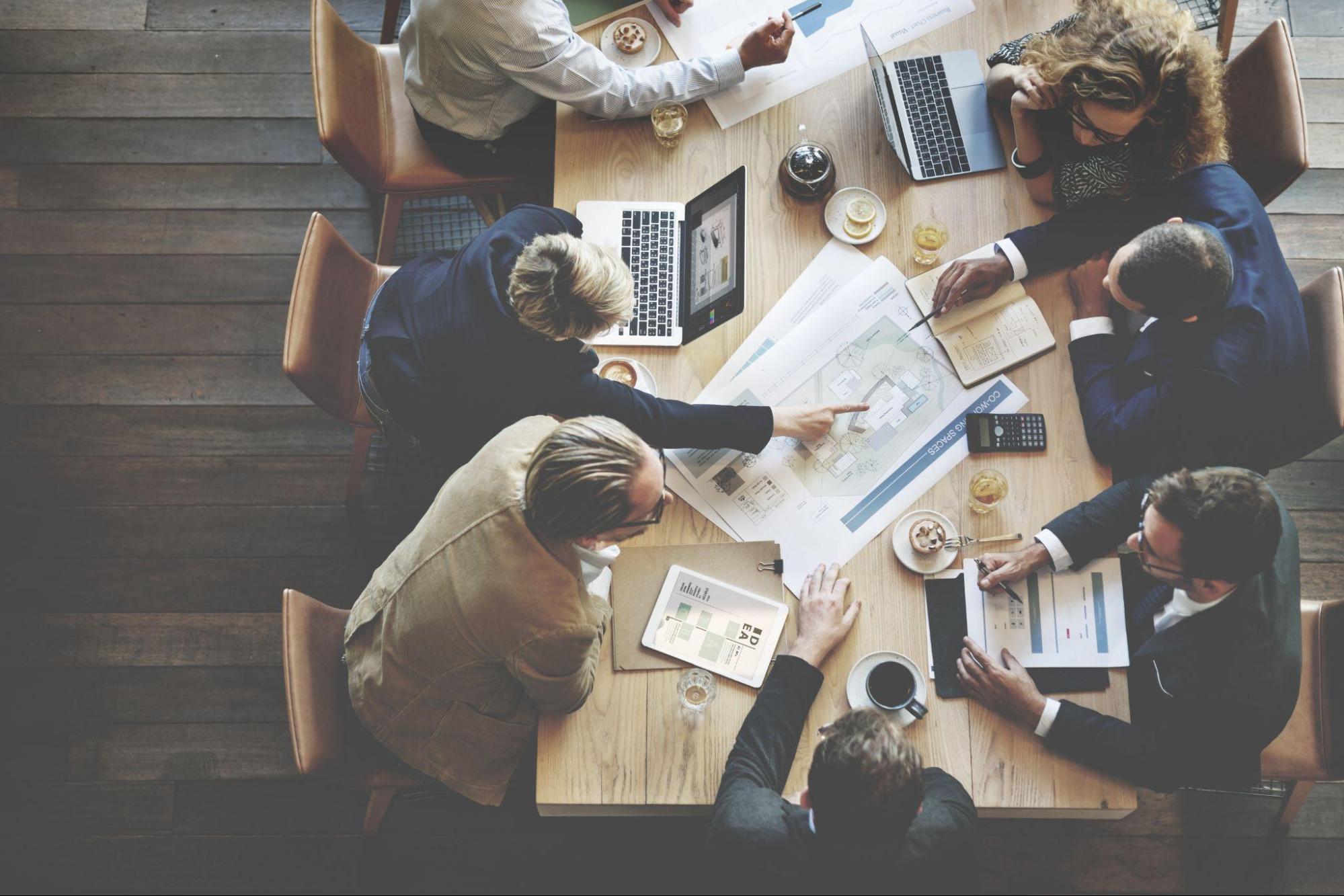 Business professionals engaged in a conference meeting in a well-lit boardroom.