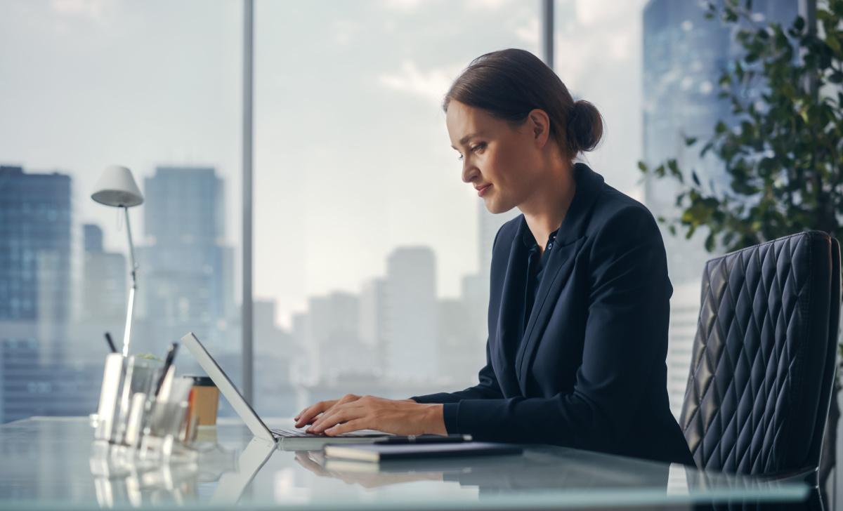 Corporate professional works in their office with a skyline view