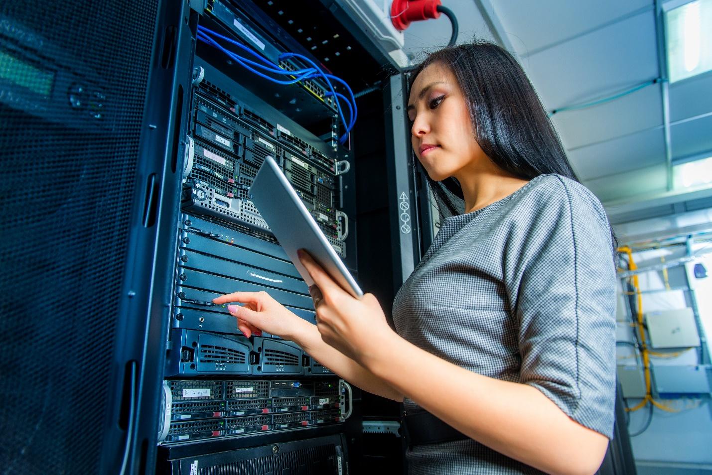 A tech worker working with a data enclosure.