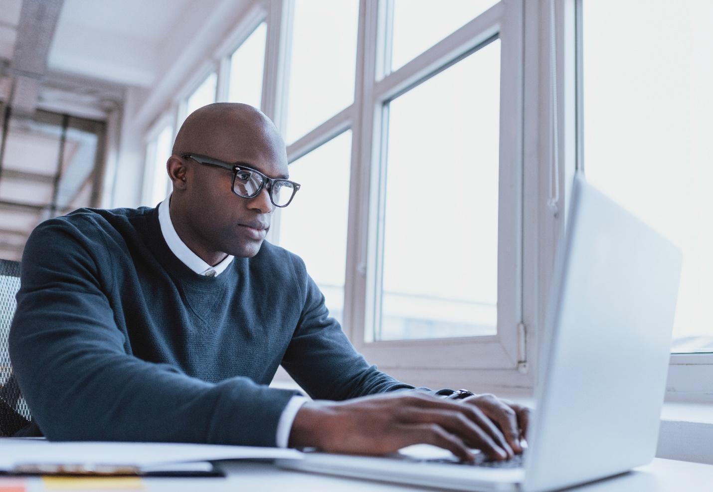 A cybersecurity professional working at their laptop computer