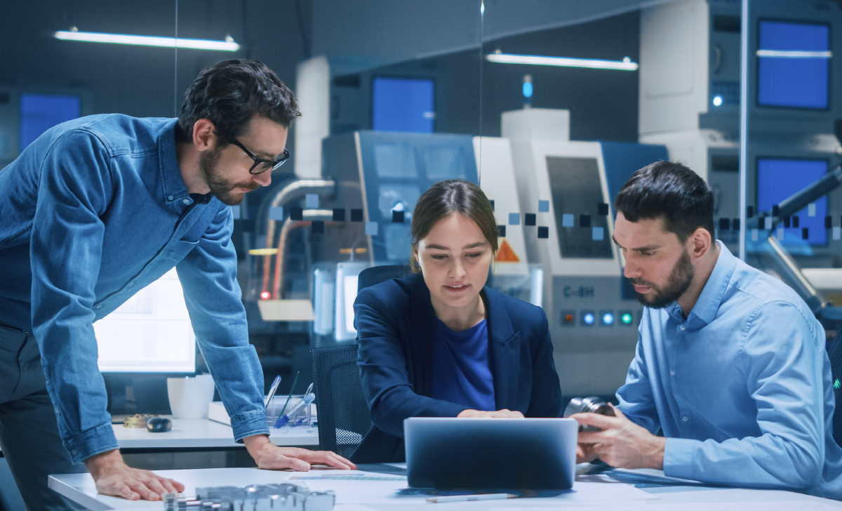 3 tech professionals working at a computer in an office