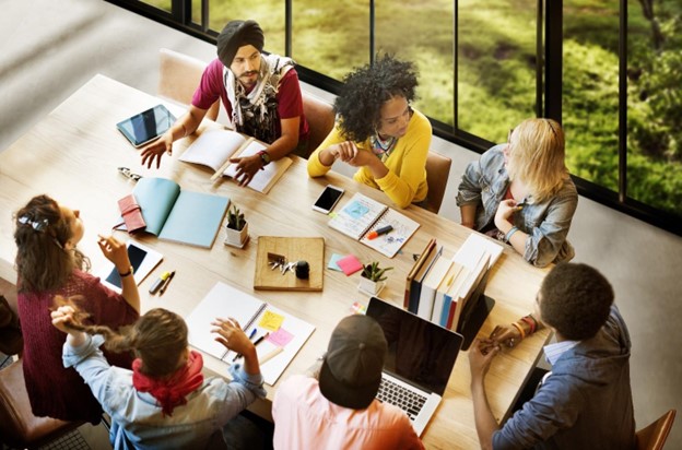 A group of IT professionals working together at an office table.