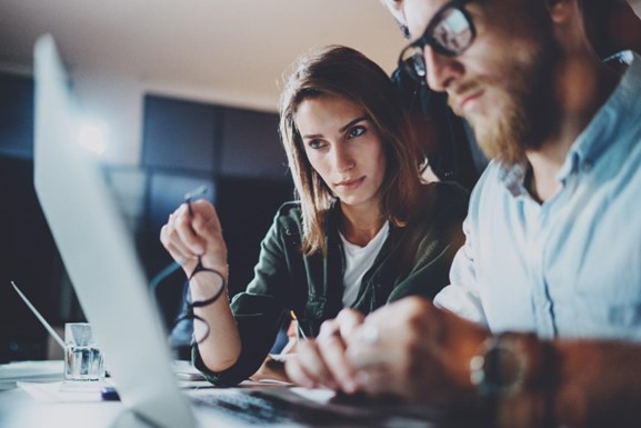 Two MSP professionals looking over data for cybersecurity reporting.