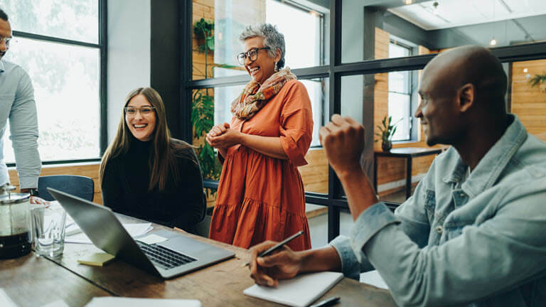 people laughing gathered around a conference table